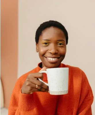 Mujer tomándose una taza de café después de haberse hecho un lifting de pestañas en TrueStudio.
